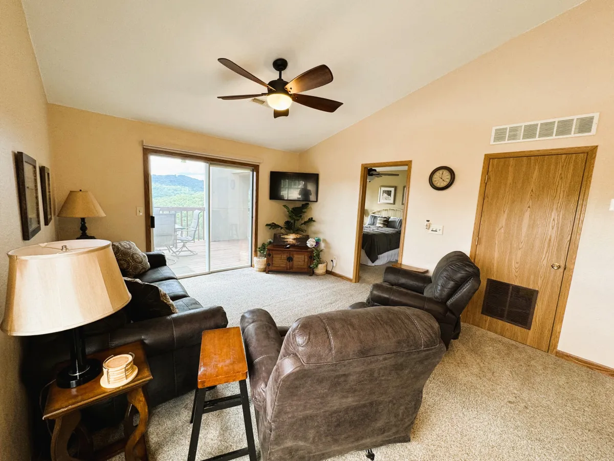A cozy, well-lit seating area with large windows offering views outside, a comfortable sofa and chairs, and a coffee table—an ideal spot for relaxing after a busy day or enjoying quiet moments with loved ones. The decor and soft lighting create a warm, inviting mood.